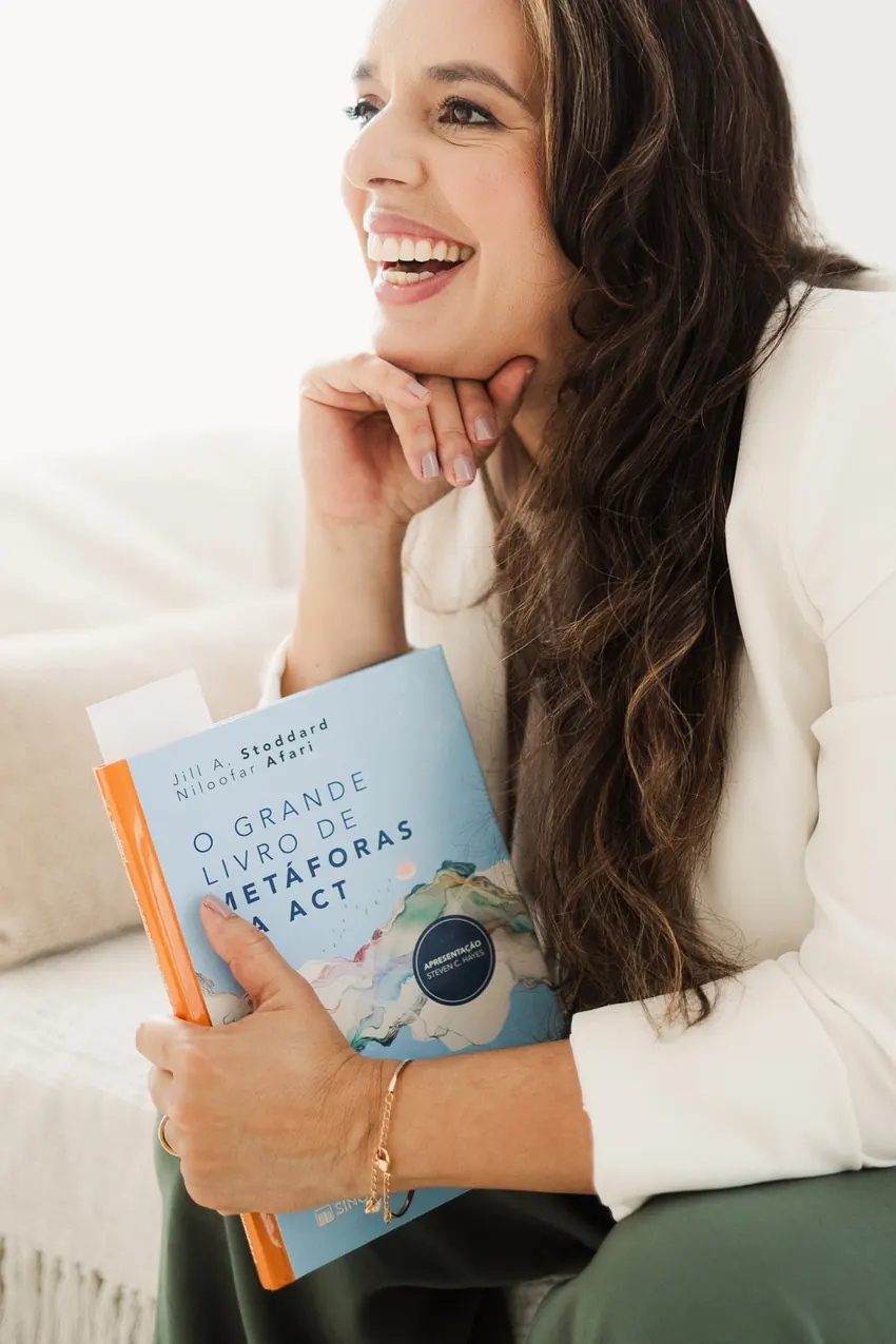 Kátia Landim sorrindo, com um livro nas mãos